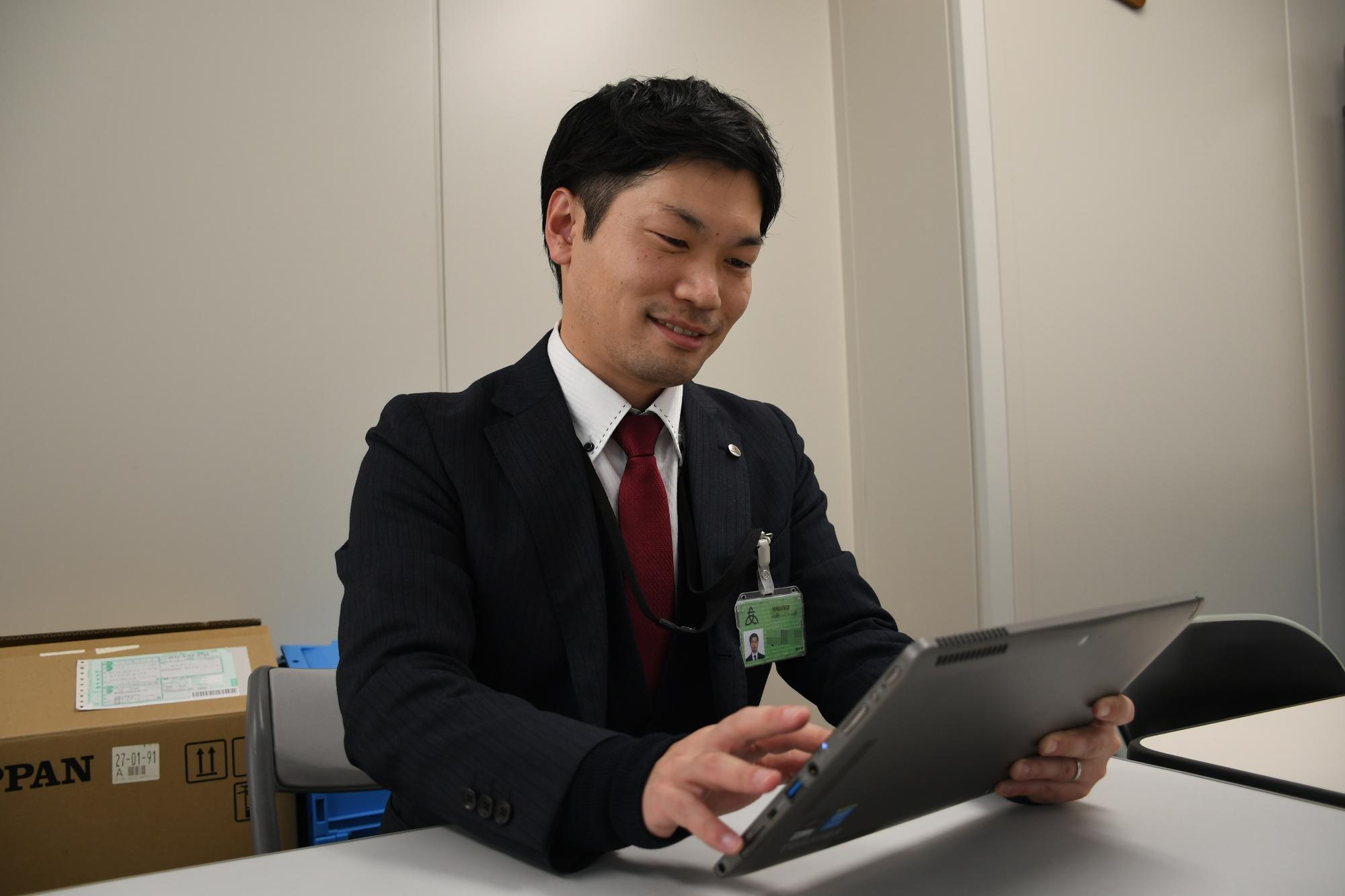 タブレット端末を使って作業をしている男性職員の写真